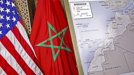 (FILES) This file photo taken on December 12, 2020 shows (L to R) US and Moroccan flags next to a US State Department-authorised map of Morocco recognising the internationally-disputed territory of the Western Sahara (bearing a signature by US Ambassador to Morocco David T. Fischer) as a part of the North African kingdom, in Morocco's capital Rabat. - US President Donald Trump's surprise backing of Morocco's claim to sovereignty over disputed Western Sahara upended years of international consensus, but will this break a deadlock or inflame a conflict? (Photo by - / AFP)