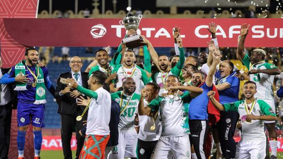 Raja Casablanca's players celebrate with the CAF Super Cup trophy after winning the match against ES Tunis at Thani bin Jassim Stadium in Al-Rayyan, Qatar, on March 29, 2019. (Photo by KARIM JAAFAR / AFP) (Photo credit should read KARIM JAAFAR/AFP via Getty Images)