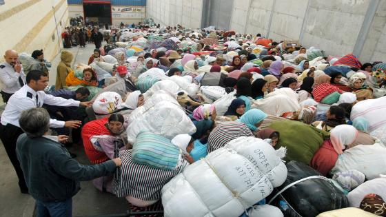 Spanish Police controls hundreds of Moroccan women waiting to pass the border between Spain and Morocco in Ceuta, 25 October 2005. These women make a living by smuggling various merchandise bought on the Spanish side of the border, which they will usually throw on the other side of the perimeter fence. But police controls along the fence have been reinforced with the current immigration crisis in Ceuta and Melilla, and the women have now to go through the usual checkpoints with their load, which the Moroccan police wants to inspect and tax, generating huge traffic jams. AFP PHOTO FIDEL RASO / AFP PHOTO / FIDEL RASO