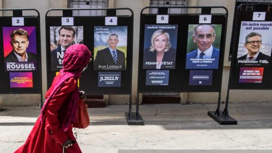 A woman walks past campaign posters at the French Embassy in Dakar on April 10, 2022, after voting in Frances first round of Presidential elections. (Photo by JOHN WESSELS / AFP) (Photo by JOHN WESSELS/AFP via Getty Images)