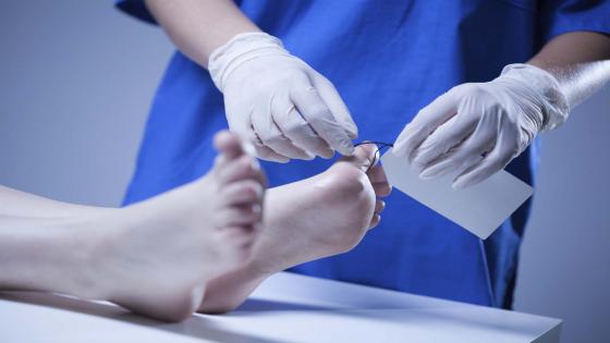 Closeup of nurse labeling of corpse in morgue